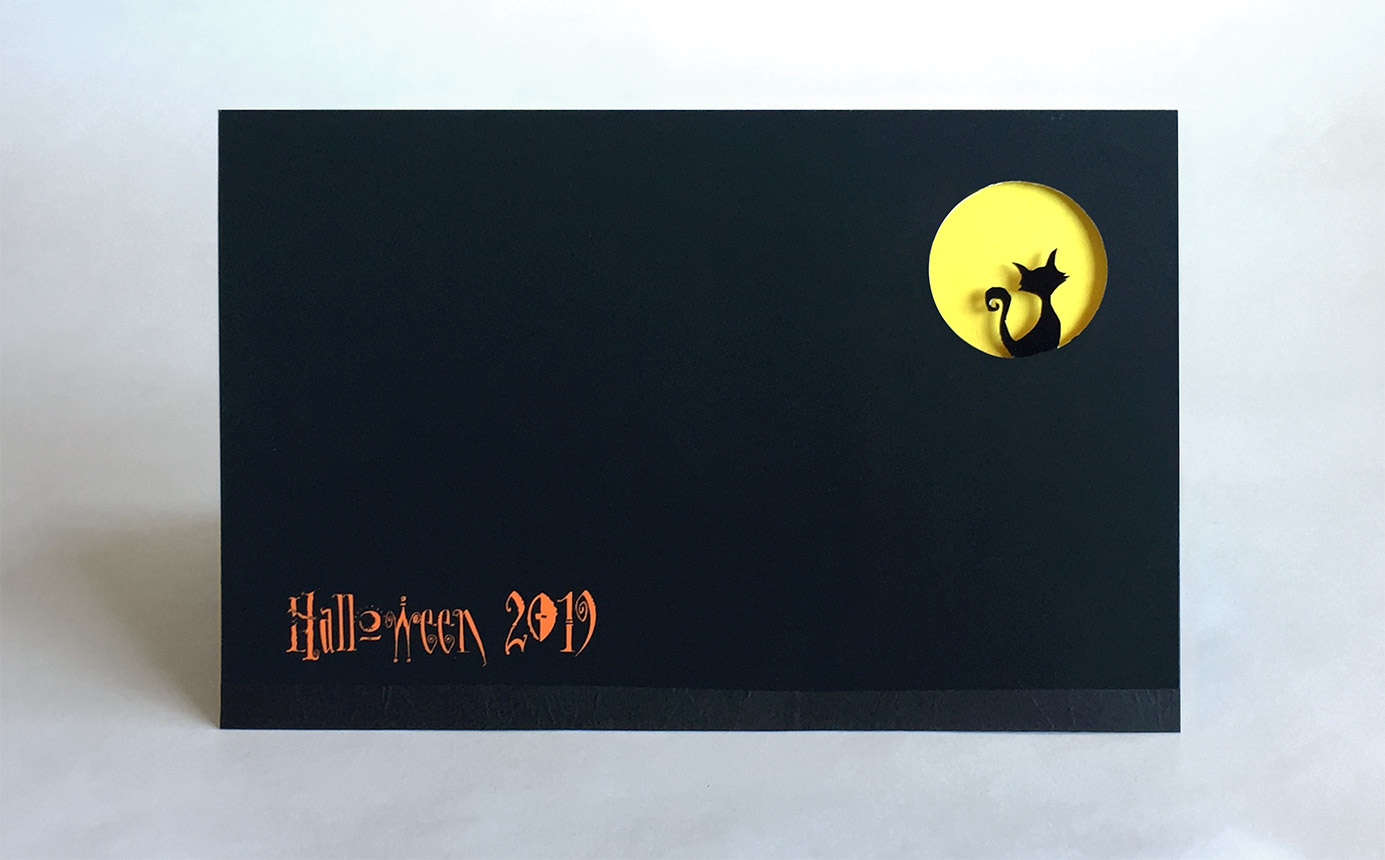 Cover of card is black with silhouette of cat in front of yellow moon