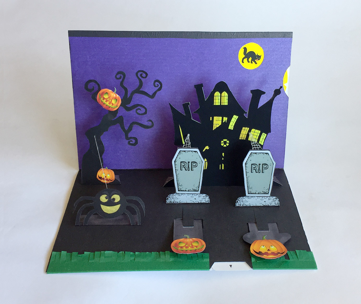 Inside of the card shows grave yard in front of haunted house